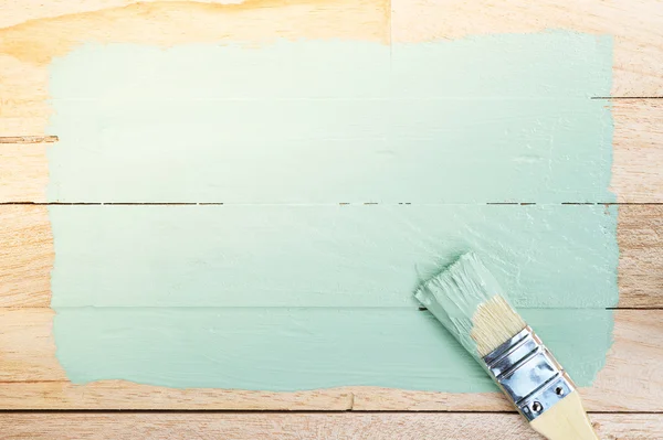 Grön färg utrymme med pensel på trä bakgrund — Stockfoto