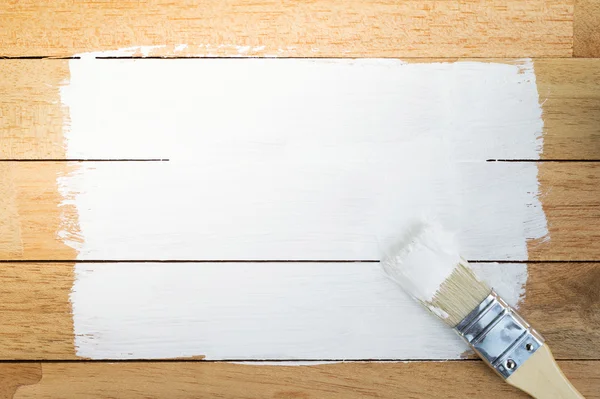 Vit färg utrymme med pensel på trä bakgrund — Stockfoto