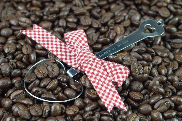 Grãos de café e colher metálica decorada — Fotografia de Stock