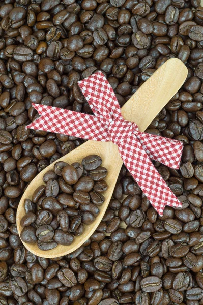 Grãos de café e colher de madeira decorada — Fotografia de Stock