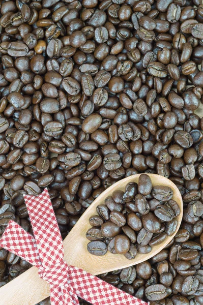 Grãos de café e colher de madeira decorada — Fotografia de Stock