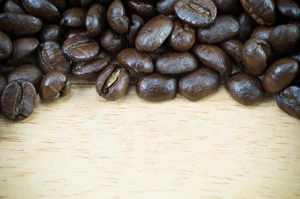 Grãos de café em fundo de madeira com espaço de cópia — Fotografia de Stock