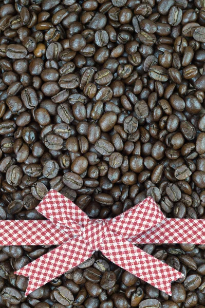 Fita de tartan vermelho em grãos de café fundo — Fotografia de Stock