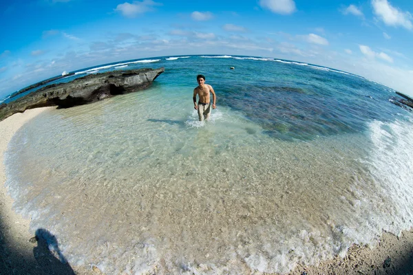 Homme debout dans l'eau sur la plage — Photo