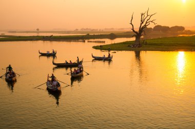 Gün batımını izlemek için turistler teknede oturuyor