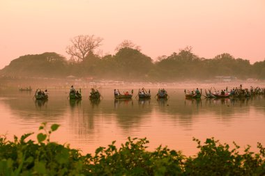 Gün batımını izlemek için turistler teknede oturuyor