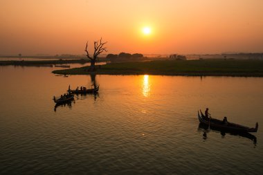 Gün batımını izlemek için turistler teknede oturuyor