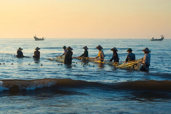 Pescadores na praia ao nascer do sol — Fotografia de Stock