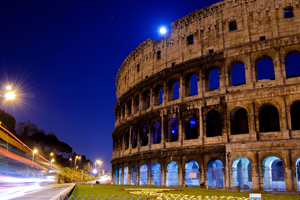 Colosseum by night in Rome moon and street lights
