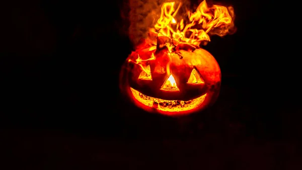 Cabeza de calabaza de halloween ardiente en la noche sobre fondo oscuro. Fondo festivo oscuro de Halloween. Enfoque suave — Foto de Stock
