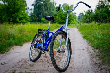 Açık havada toprak bir yolda mavi bisiklet