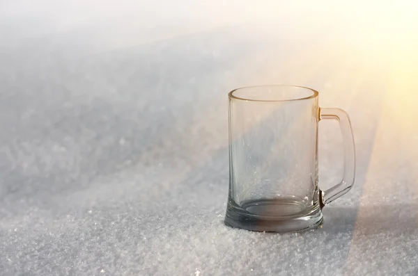Glass mug in the snow — Stock Photo, Image
