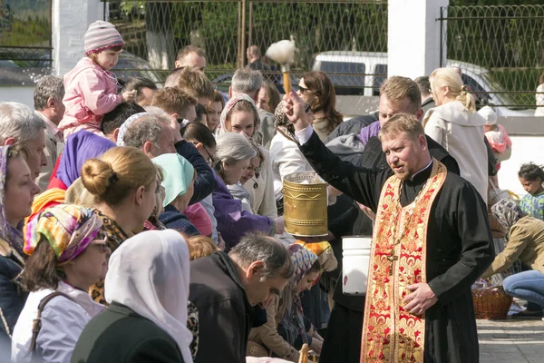 Sacerdote ortodoxo salpica el agua bendita en pasteles de Pascua — Foto de Stock