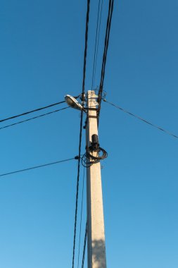 Elektrik direği ve mavi gökyüzü arka plan üzerinde teller 