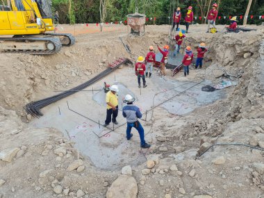 Dağdaki inşaat alanına beton döken beton çelik bir formdaydı. Kırmızı gömlekli işçiler yüzlerini tahta bir blokla düzeltiyorlardı..