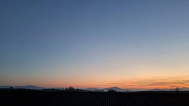 Dağların ve ağaçların üzerinden sabah bulanıklığı. Gökyüzündeki ilk ve son gün ışığı güzel bulutlar ve arka plan olarak güneş ışığı.