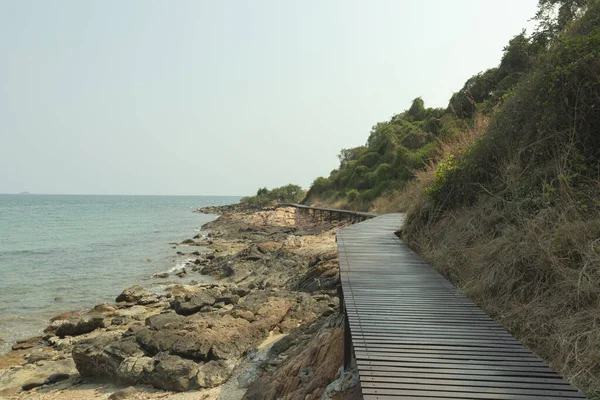 해변에 바위들 갈색의 다리들은 산비탈을 바위가 과가까운 바다에 위치하고 — 스톡 사진