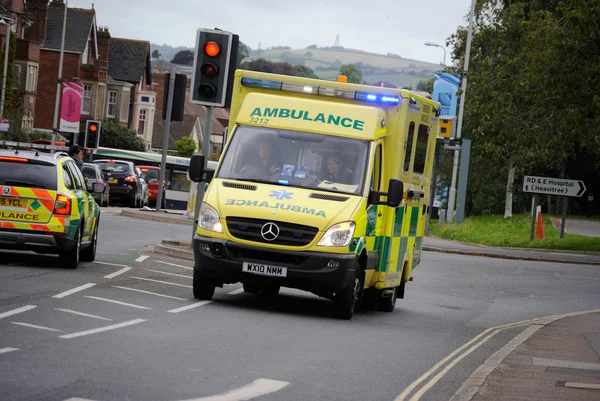 Ambulance med blåt lys tændt . - Stock-foto