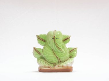 Hindu tanrısı Ganesh yeşil yaprak heykeli beyaz arka planda izole edilmiş.