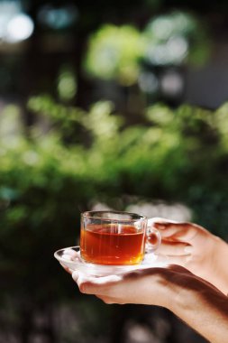 Bir kadının kaplıcada çay içerken çekilmiş bir fotoğrafı.