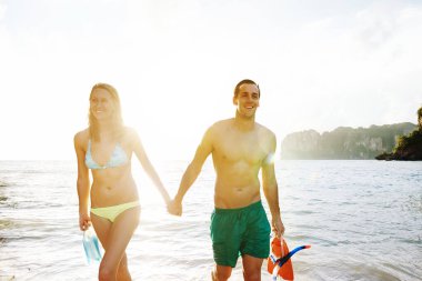 Genç bir çiftin günü sahilde geçirmesi.