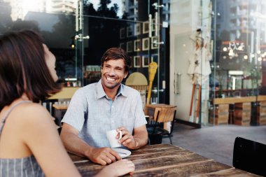 Genç bir çiftin kaldırımdaki kafede kahve içerken çekilmiş görüntüleri.
