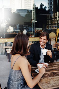 Genç bir çiftin kaldırımdaki kafede kahve içerken çekilmiş görüntüleri.