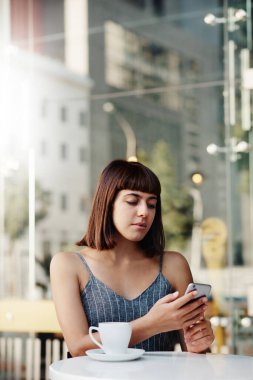 Çekici bir genç kadının kahve dükkanında çekilmiş fotoğrafı.