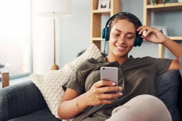 Downloading the latest songs to her phone — Stockfoto