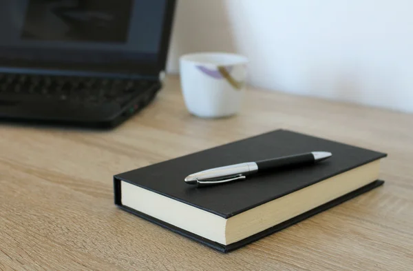 Werkruimte met laptop, koffie, pen en papier — Stockfoto