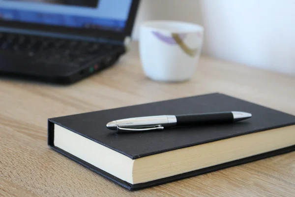 Werkruimte met laptop, koffie, pen en papier — Stockfoto