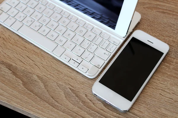 White smartphone and white tablet with keyboard Royalty Free Stock Images
