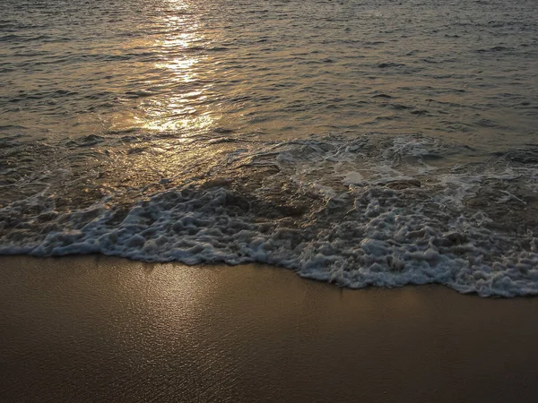 Sahildeki deniz dalgalarında batan güneşin yansıması. Geçmişi. Uzayı kopyala, seyahat fotoğrafı