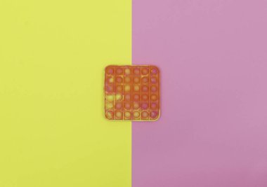 Pembe ve sarı arka planda stres önleyici oyuncağı tak..