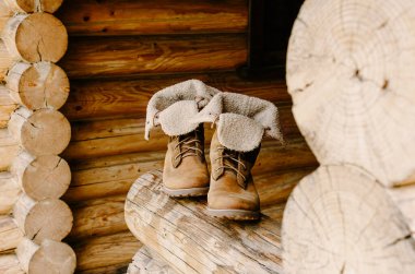 Kır evinin verandasında duran kahverengi yürüyüş botları..