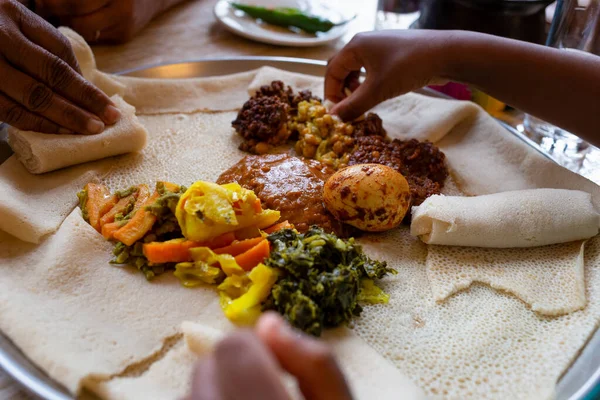 Sharing a vegetarian Injera meal with shiro, lentils and egg