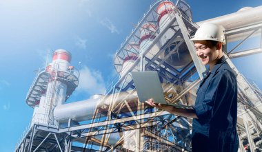 Fabrikada dizüstü bilgisayar kullanan mühendis.