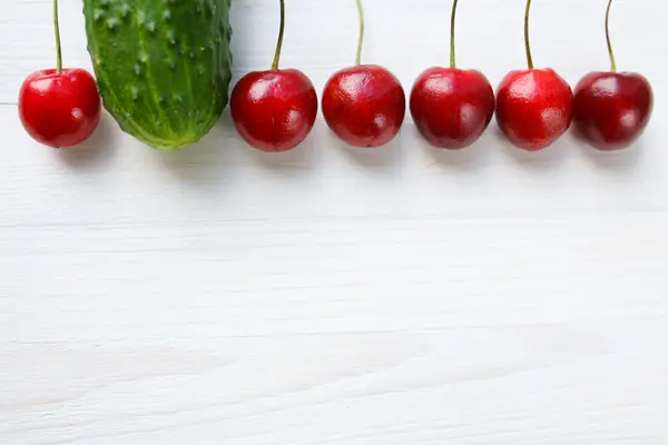 Cherries in a row, red and green — Stock Photo, Image