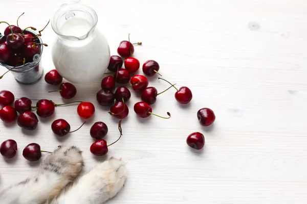 Jug of milk and cherries — Stock Photo, Image