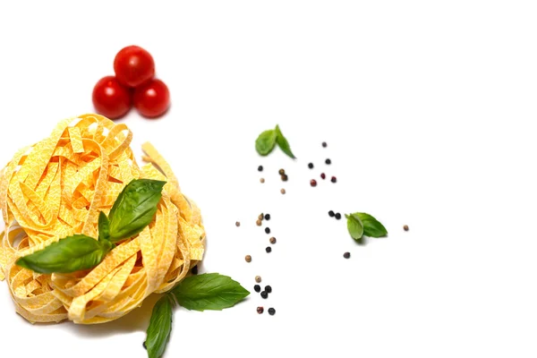 Nest of dry pasta with cherry tomatoes, basil and pepper — Stock Photo, Image