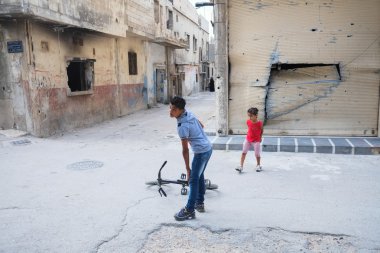 Children play near damaged houses clipart