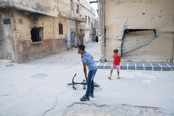 Children play near damaged houses — Stock Photo, Image