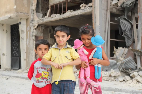 Children play near damaged houses — Stock Photo, Image