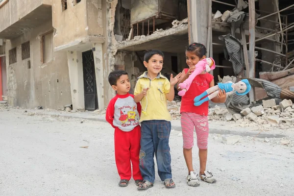 Children play near damaged houses — Stock Photo, Image