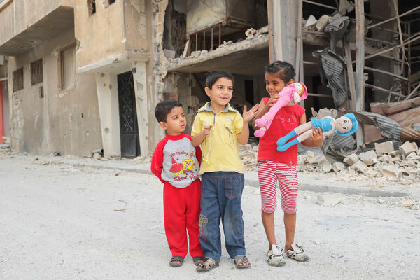 Children play near damaged houses