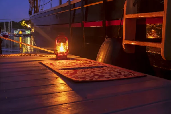 Welcoming lantern in the evening in the harbor at a Maine cruising schooner
