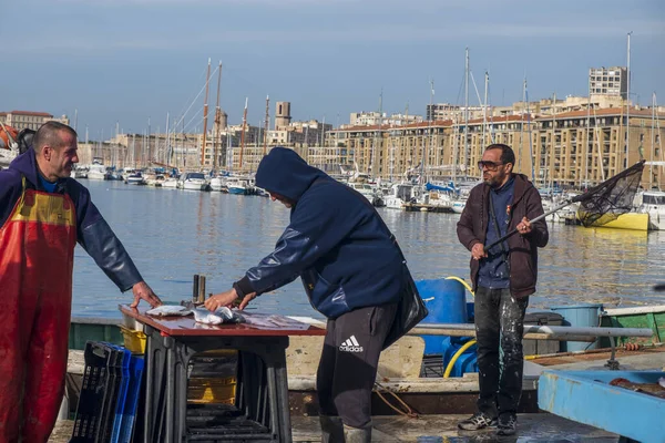 Fishermen displaying their wares at an outdoor fish market at the harbor in Marseille, France