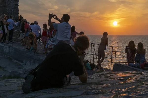 İtalya kıyılarında Porto Venere 'de renkli bir günbatımının tadını çıkaran turistler