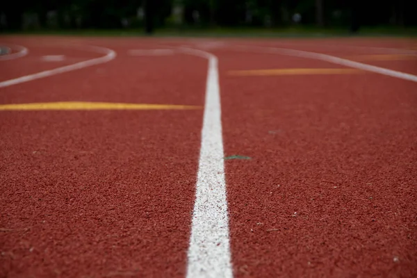 White lane lines on a red running track await the competitors