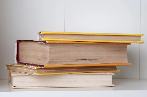 Stack of hardback books on wooden bookshelf. — Stock Photo, Image